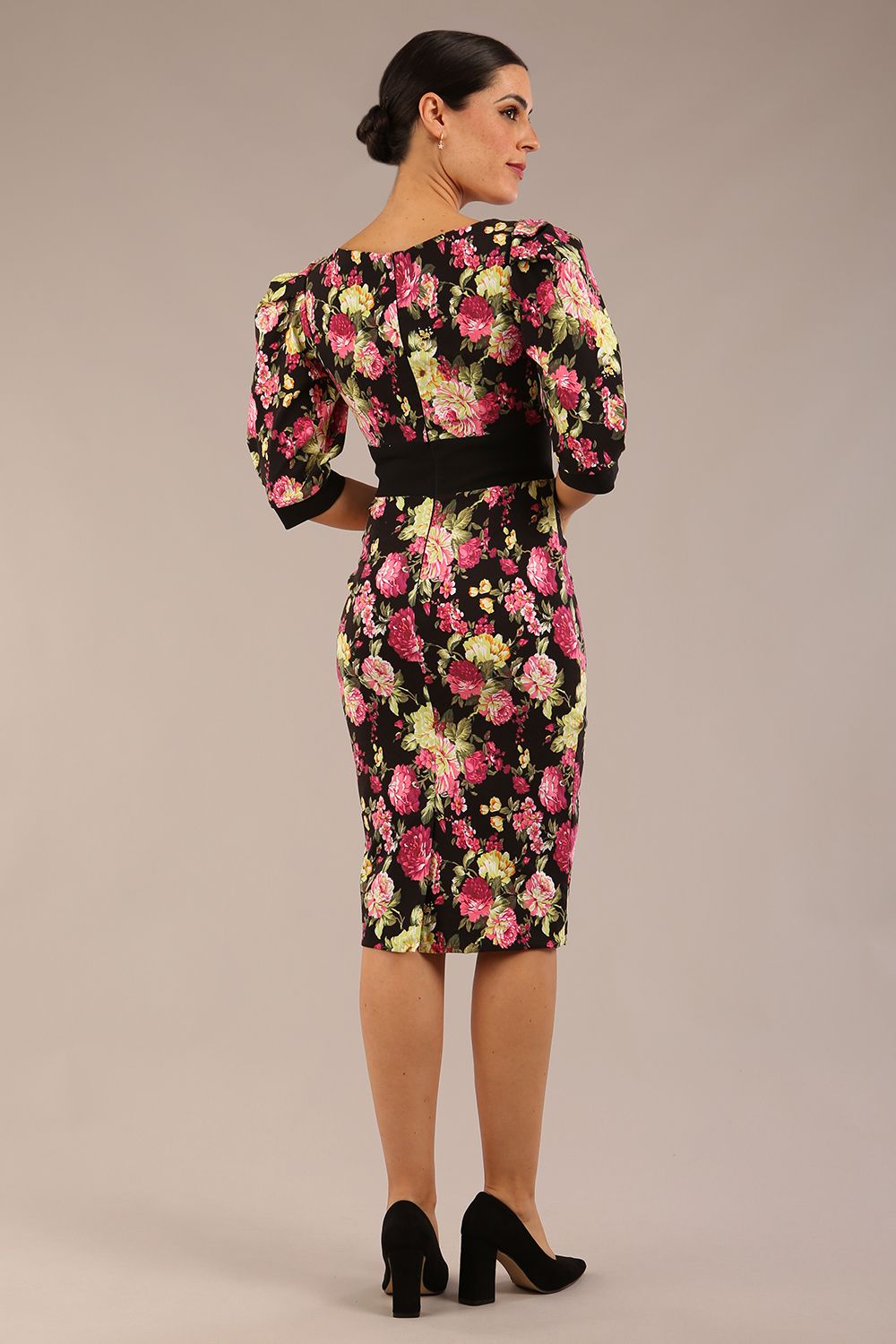 The brunette model is wearing a 7004 diva catwalk  Somerset Floral with Puff Sleeves & Black Waistband v neckline and knee length Pencil Dress in Black Spring Flower print front image