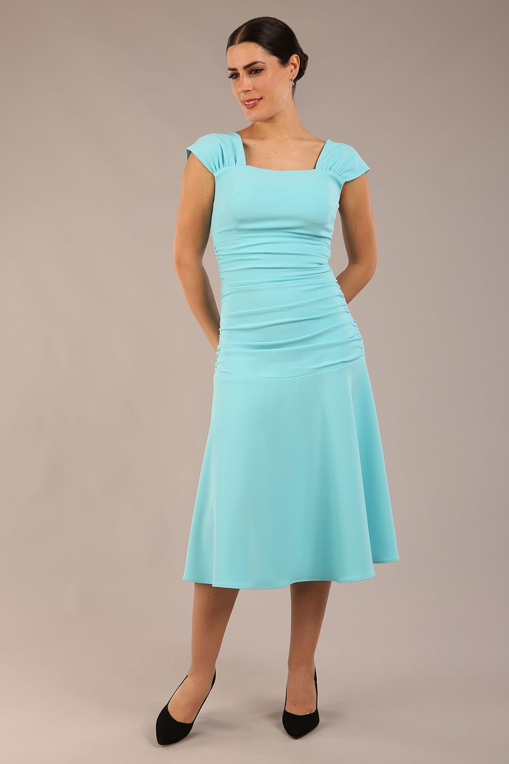 brunette model is wearing a diva catwalk Sonning Cap Sleeve Square Neckline A-Line midi Dress and rushing side details in turquoise colour front