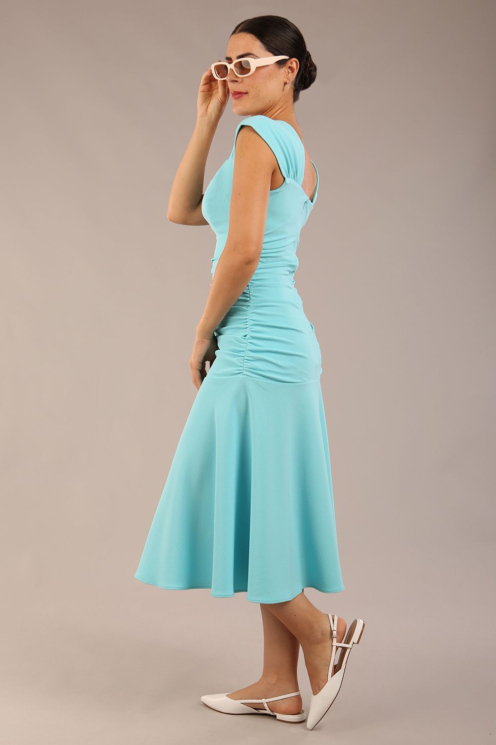 brunette model is wearing a diva catwalk Sonning Cap Sleeve Square Neckline A-Line midi Dress and rushing side details in turquoise colour front