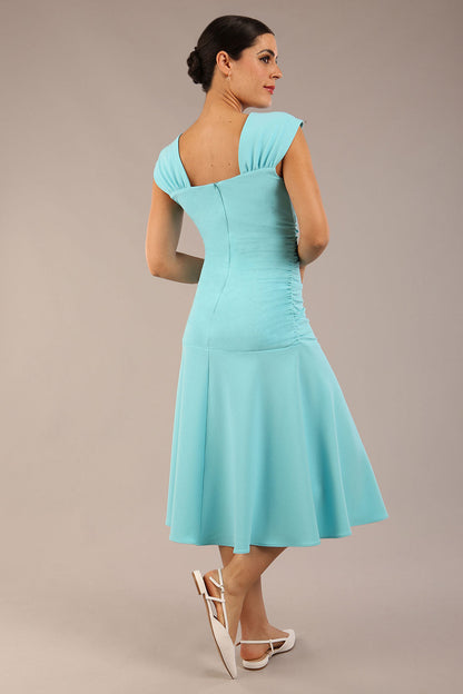 brunette model is wearing a diva catwalk Sonning Cap Sleeve Square Neckline A-Line midi Dress and rushing side details in turquoise colour front