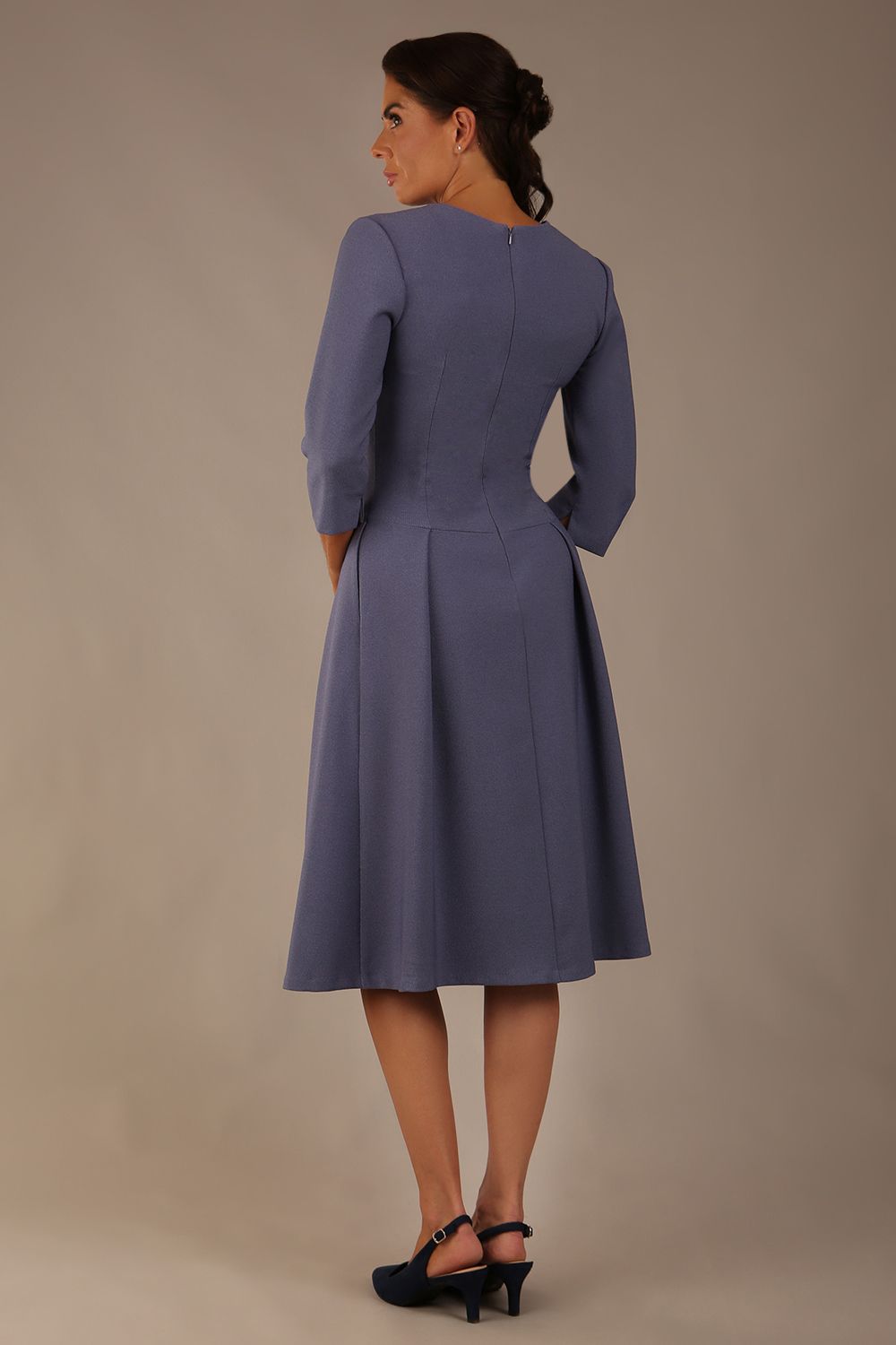 Model wearing the Ario pleated A-line dress in blue mineral, showcasing the round neckline and 3/4 sleeves (Blue Mineral)