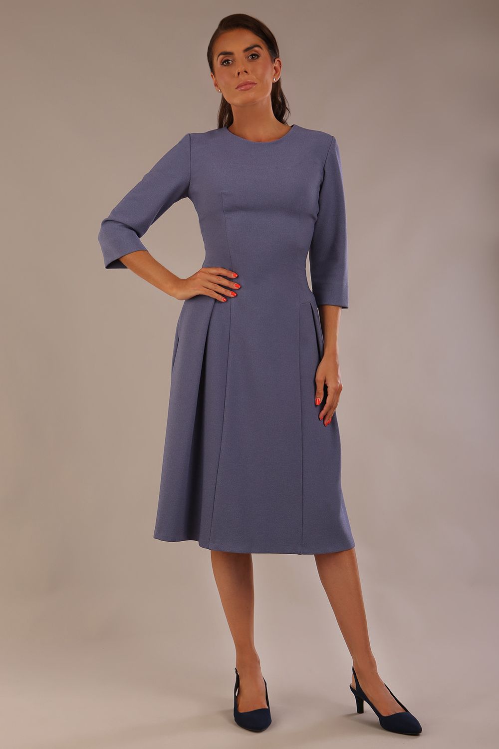 Model wearing the Ario pleated A-line dress in blue mineral, showcasing the round neckline and 3/4 sleeves (Blue Mineral)