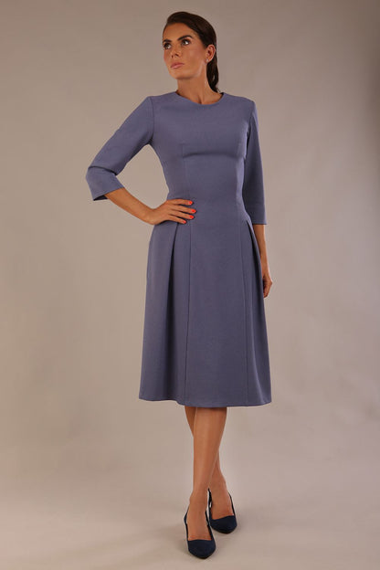 Model wearing the Ario pleated A-line dress in blue mineral, showcasing the round neckline and 3/4 sleeves (Blue Mineral)
