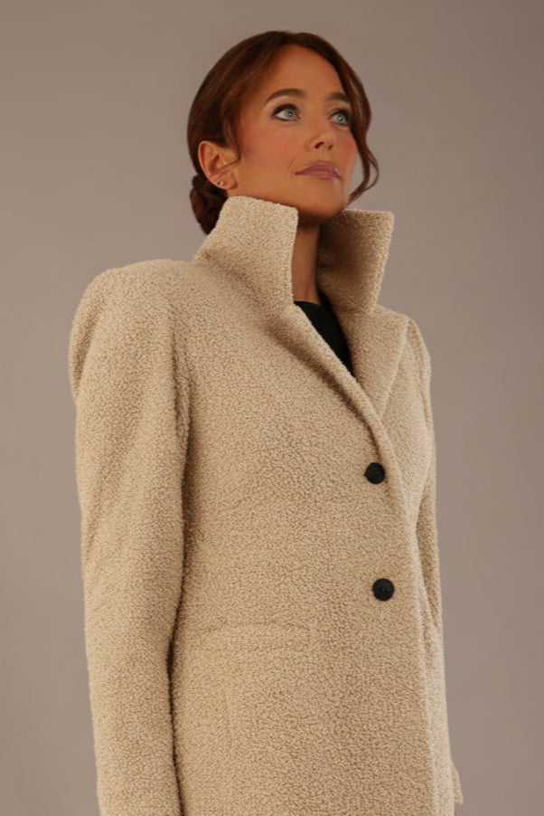 Model wearing the Ambrose boucle midi coat in pink tint, long sleeves teddy feeling with a collar neckline and 2 closure buttons at the front and pockets close up (Pink Tint)