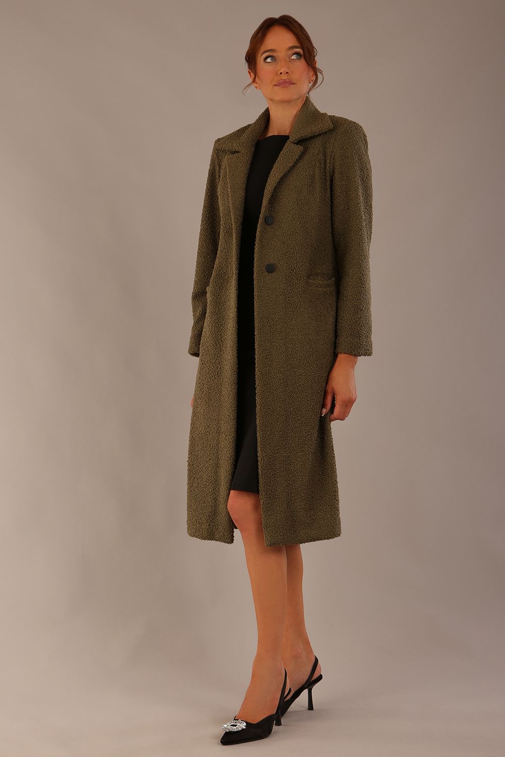 Model wearing the Ambrose boucle midi coat in olive green, long sleeves teddy feeling with a collar neckline and 2 closure buttons at the front and pockets (Olive Green)