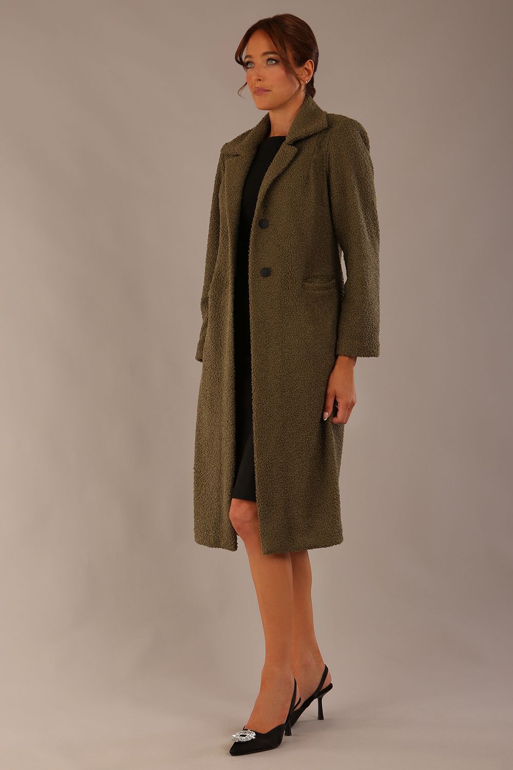 Model wearing the Ambrose boucle midi coat in olive green, long sleeves teddy feeling with a collar neckline and 2 closure buttons at the front and pockets (Olive Green)
