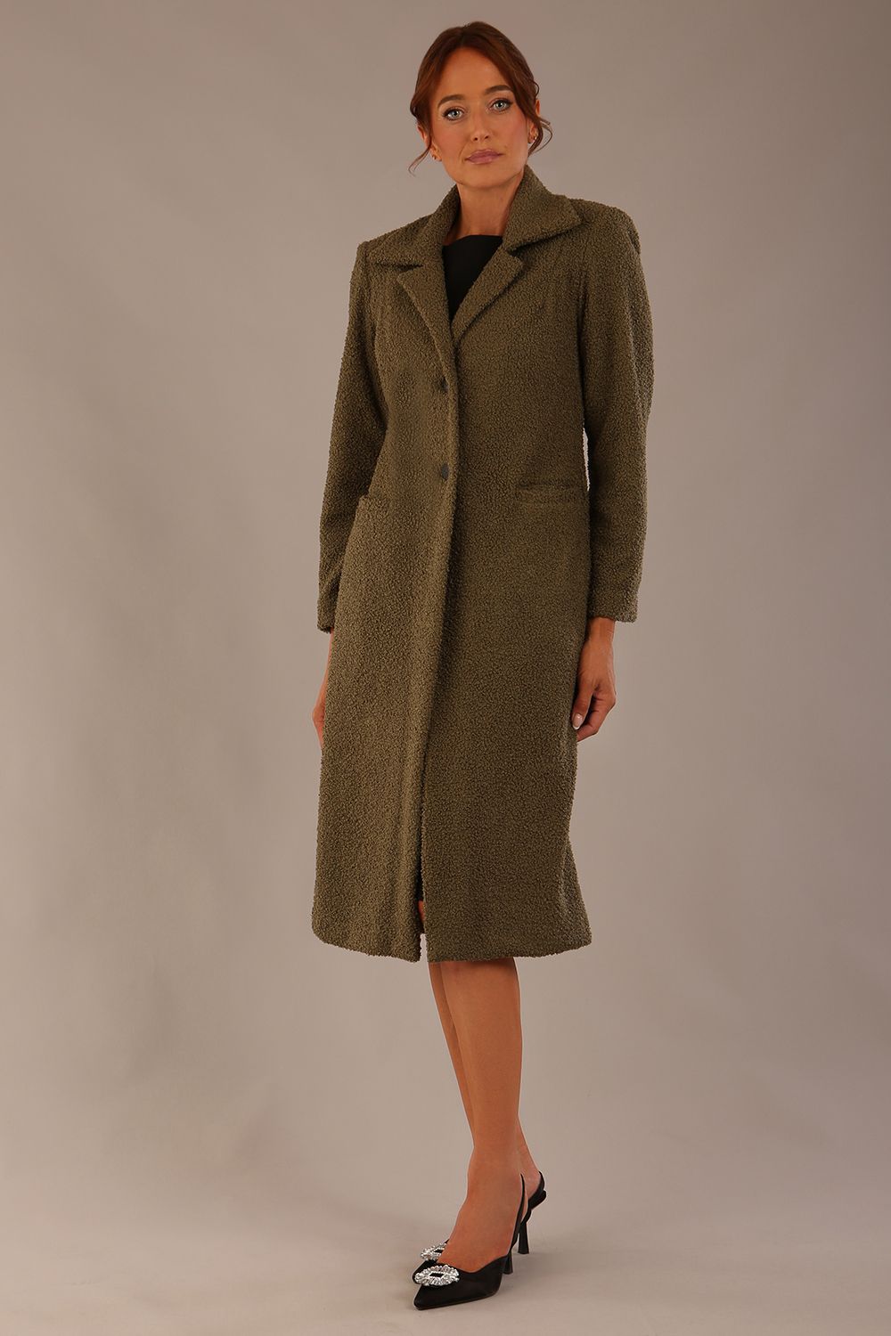 Model wearing the Ambrose boucle midi coat in olive green, long sleeves teddy feeling with a collar neckline and 2 closure buttons at the front and pockets (Olive Green)