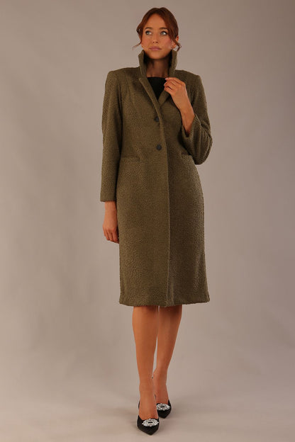 Model wearing the Ambrose boucle midi coat in olive green, long sleeves teddy feeling with a collar neckline and 2 closure buttons at the front and pockets (Olive Green)