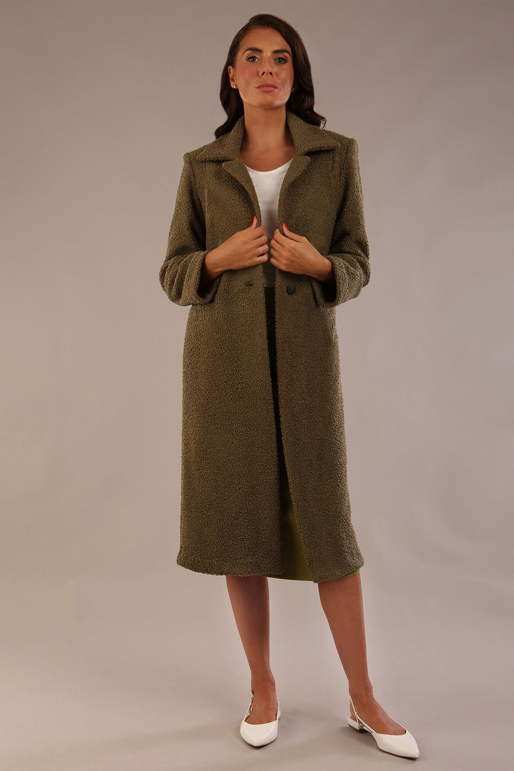 Model wearing the Ambrose boucle midi coat in olive green, long sleeves teddy feeling with a collar neckline and 2 closure buttons at the front and pockets (Olive Green)