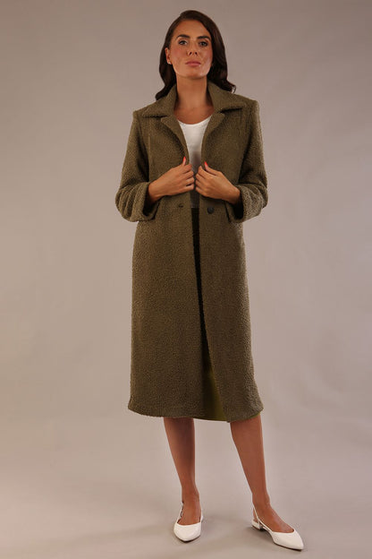 Model wearing the Ambrose boucle midi coat in olive green, long sleeves teddy feeling with a collar neckline and 2 closure buttons at the front and pockets (Olive Green)