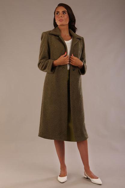 Model wearing the Ambrose boucle midi coat in olive green, long sleeves teddy feeling with a collar neckline and 2 closure buttons at the front and pockets (Olive Green)