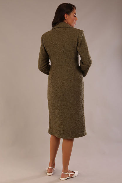 Model wearing the Ambrose boucle midi coat in olive green, long sleeves teddy feeling with a collar neckline and 2 closure buttons at the front and pockets (Olive Green)