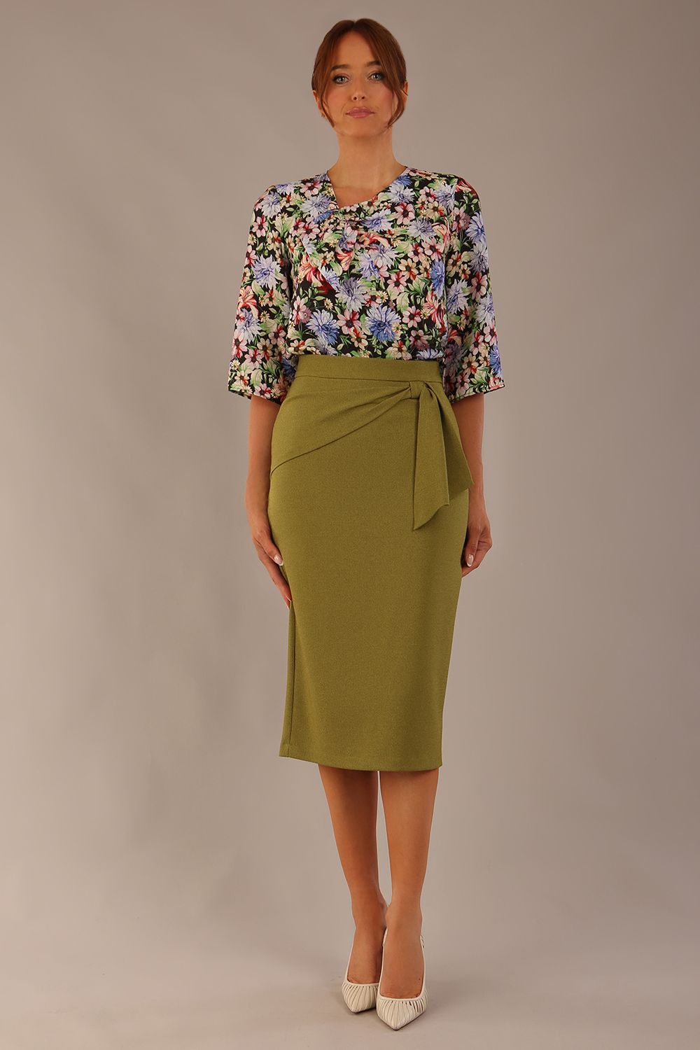 Model wearing a Suki asymmetric draped top in the Aurora Botanical print, styled with a olive green pencil skirt (Aurora Botanical)