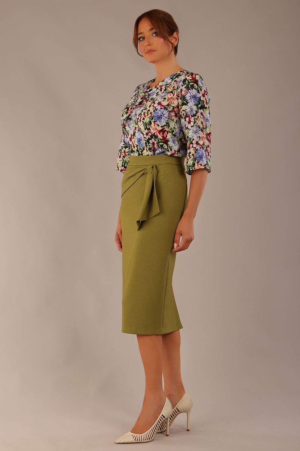 Model wearing a Suki asymmetric draped top in the Aurora Botanical print, styled with a olive green pencil skirt (Aurora Botanical)