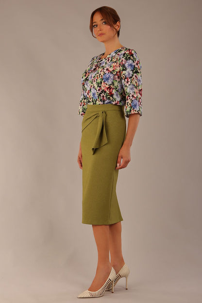 Model wearing a Suki asymmetric draped top in the Aurora Botanical print, styled with a olive green pencil skirt (Aurora Botanical)