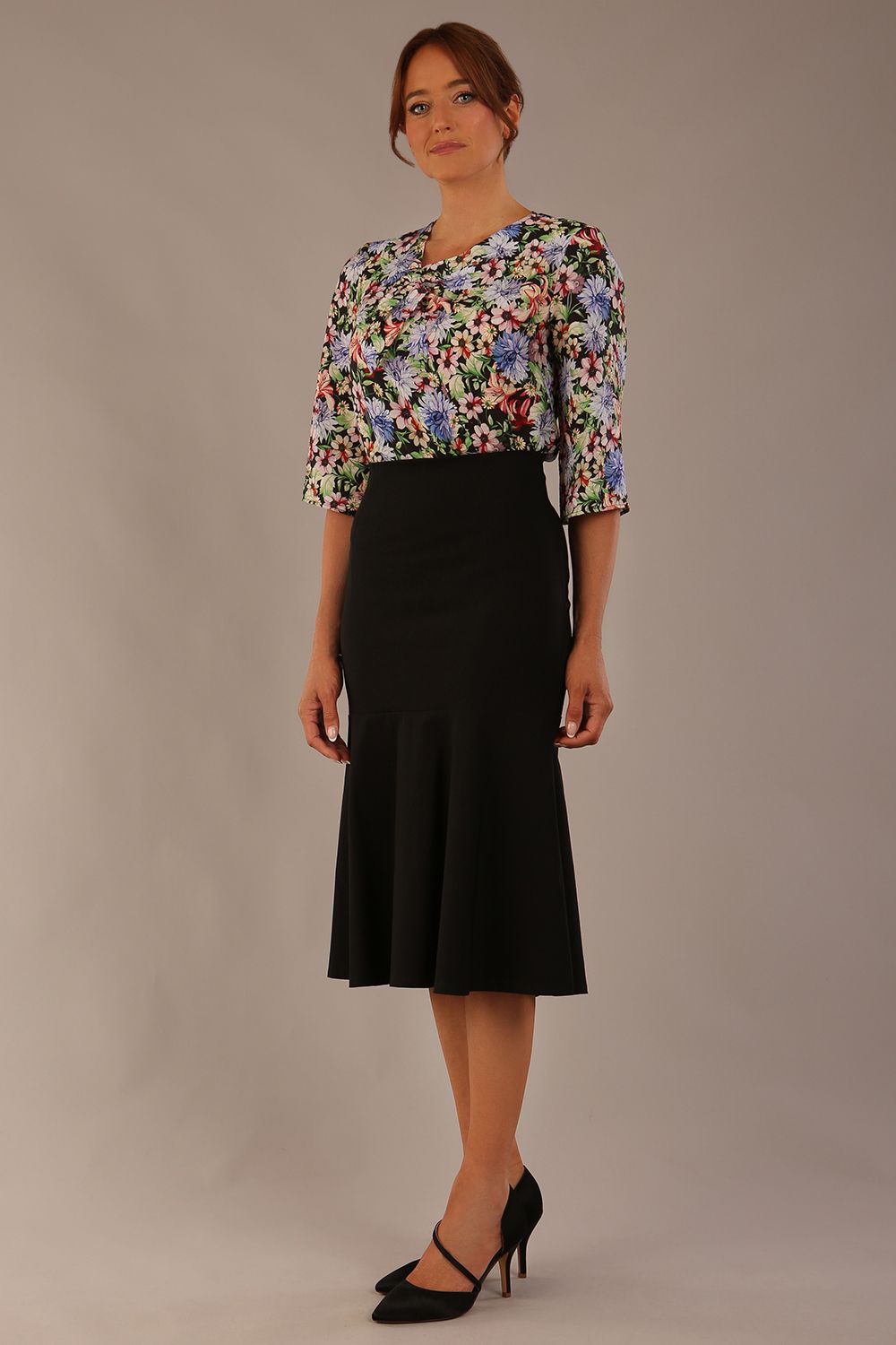 Model wearing a Suki asymmetric draped top in the Aurora Botanical print, styled with a black fishtail skirt (Aurora Botanical)