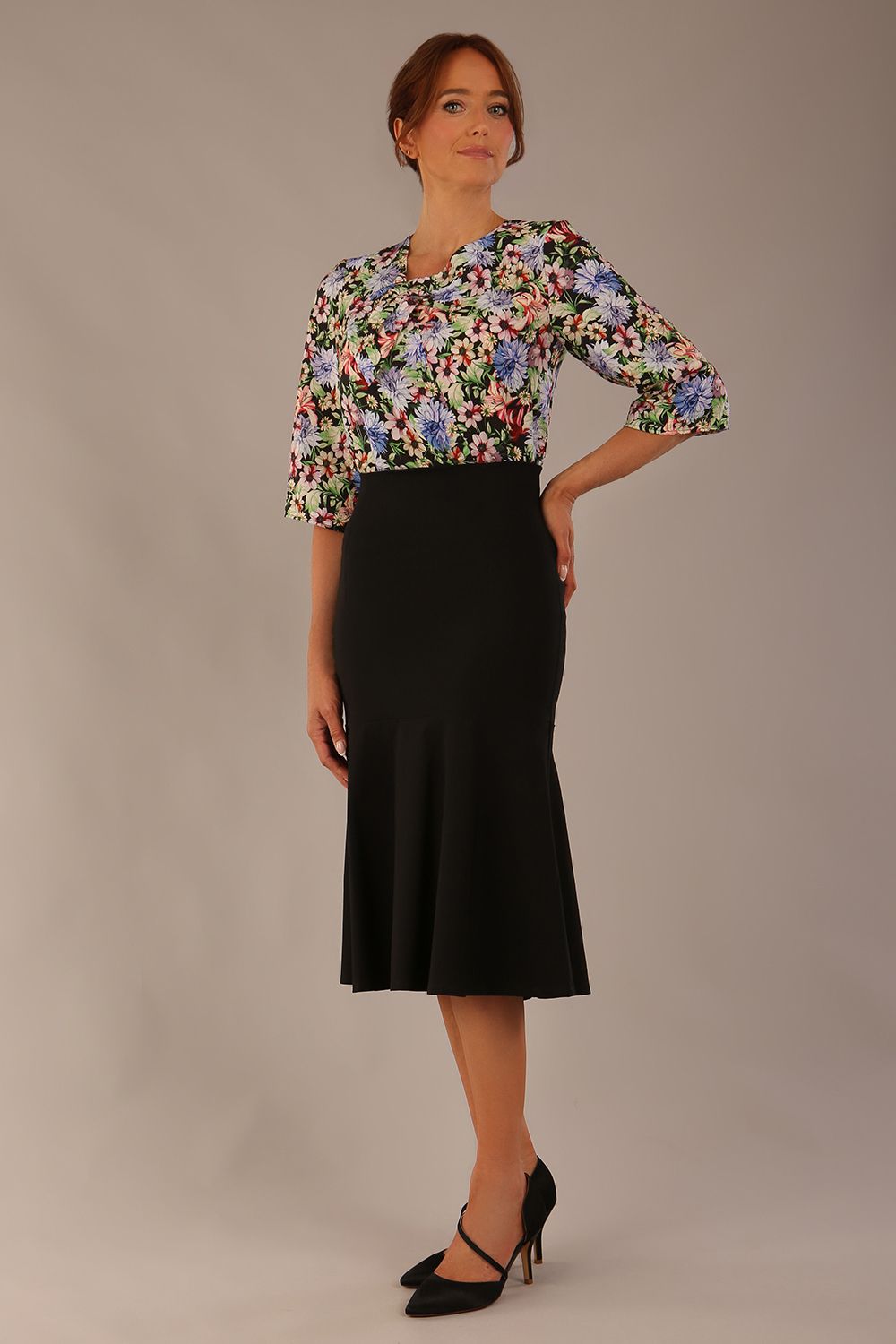 Model wearing a Suki asymmetric draped top in the Aurora Botanical print, styled with a black fishtail skirt (Aurora Botanical)