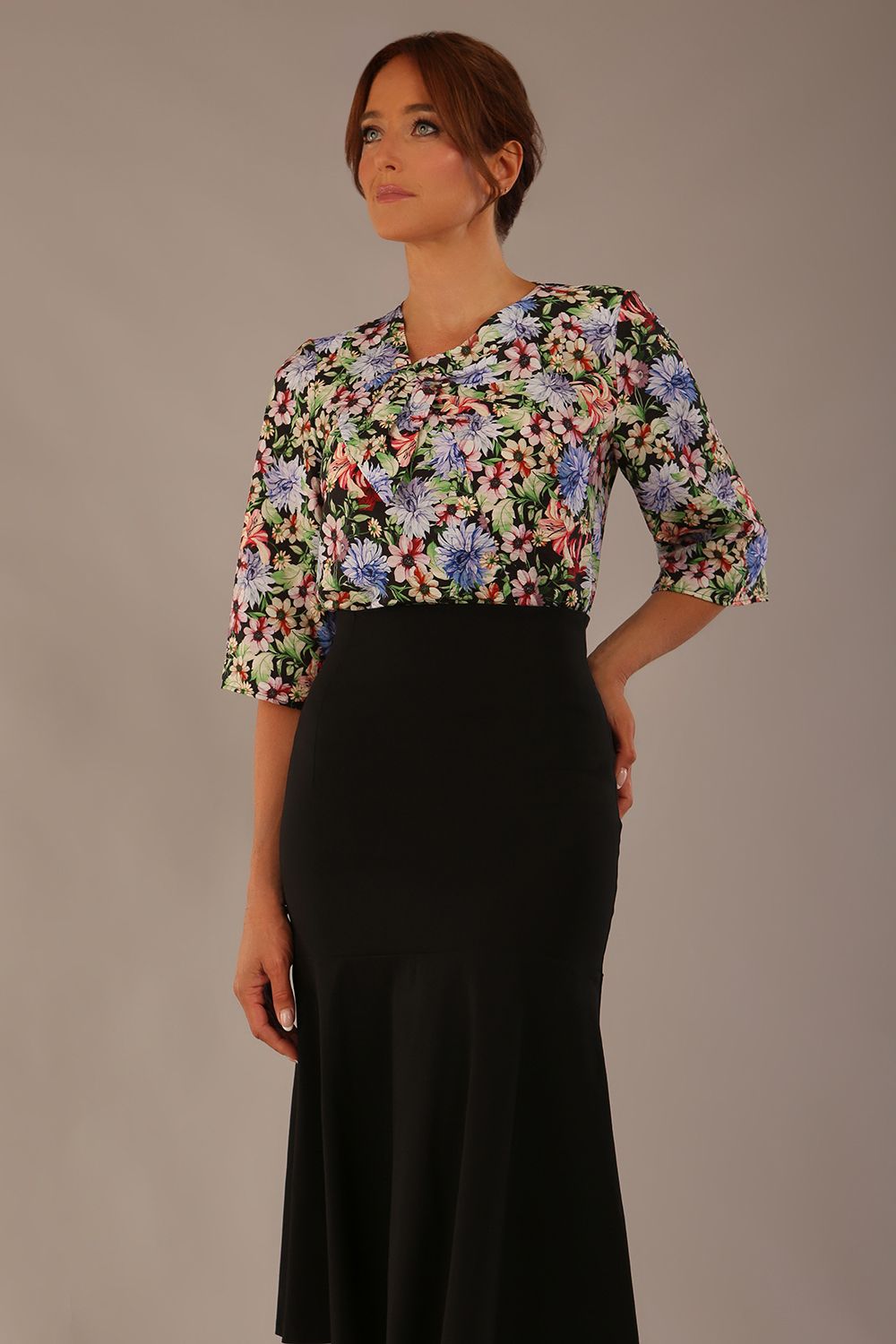 Model wearing a Suki asymmetric draped top in the Aurora Botanical print, styled with a black fishtail skirt (Aurora Botanical)