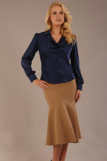 Blonde Model wearing the Shropshire top in navy blue, styled with a camel flared fishtail skirt (Navy Blue)
