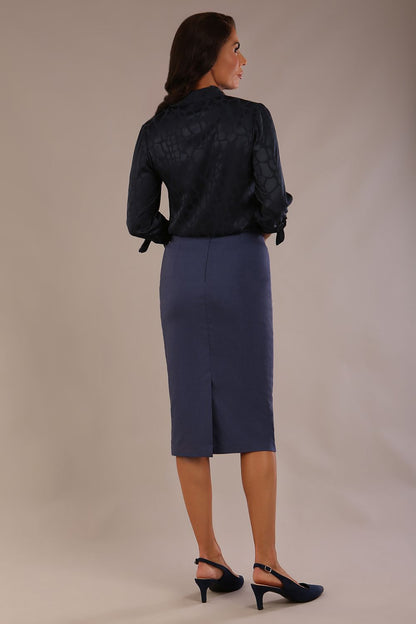 Model wearing a navy satin pebble top with a tie neckline and 3/4 sleeves, styled with a navy pencil skirt (Navy Blue)