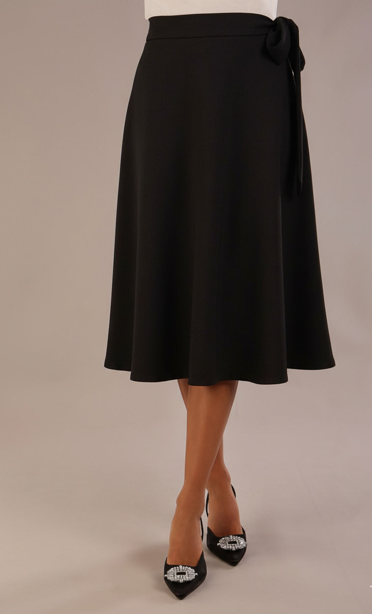 Model wearing the Harlow A-line midi skirt in black, with the side-tie fastened in a bow (Black)