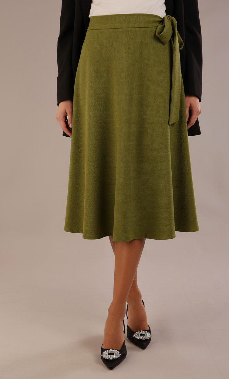 Model wearing the Harlow A-line midi skirt in oasis green, with the side-tie fastened in a bow (Oasis Green)
