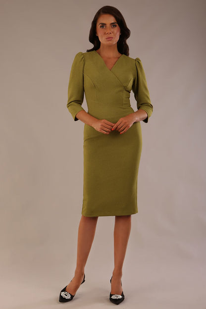 Model wearing an Ethan V-neck dress in oasis green, highlighting the flattering seams and puff shoulders (Oasis Green)