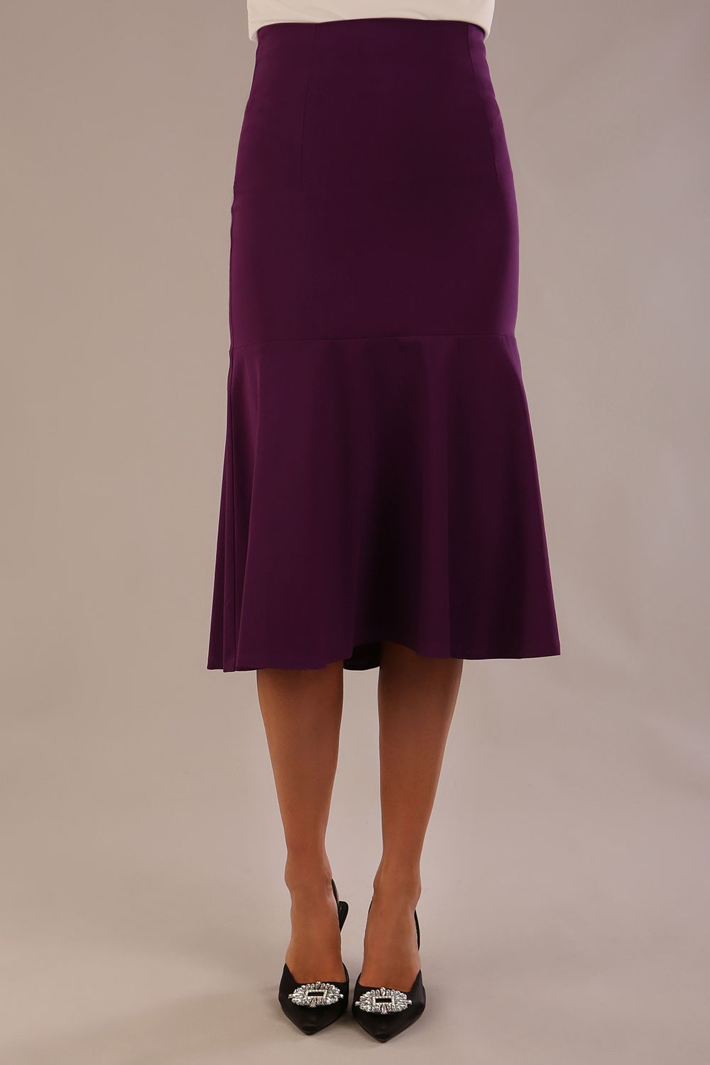 Model wearing the Truro floral top, showing the standard hip-length and draped V-neck and purple marlene skirt against a gray background (Purple)