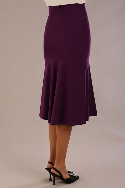 Model wearing the Truro floral top, showing the standard hip-length and draped V-neck and purple marlene skirt against a gray background (Purple)
