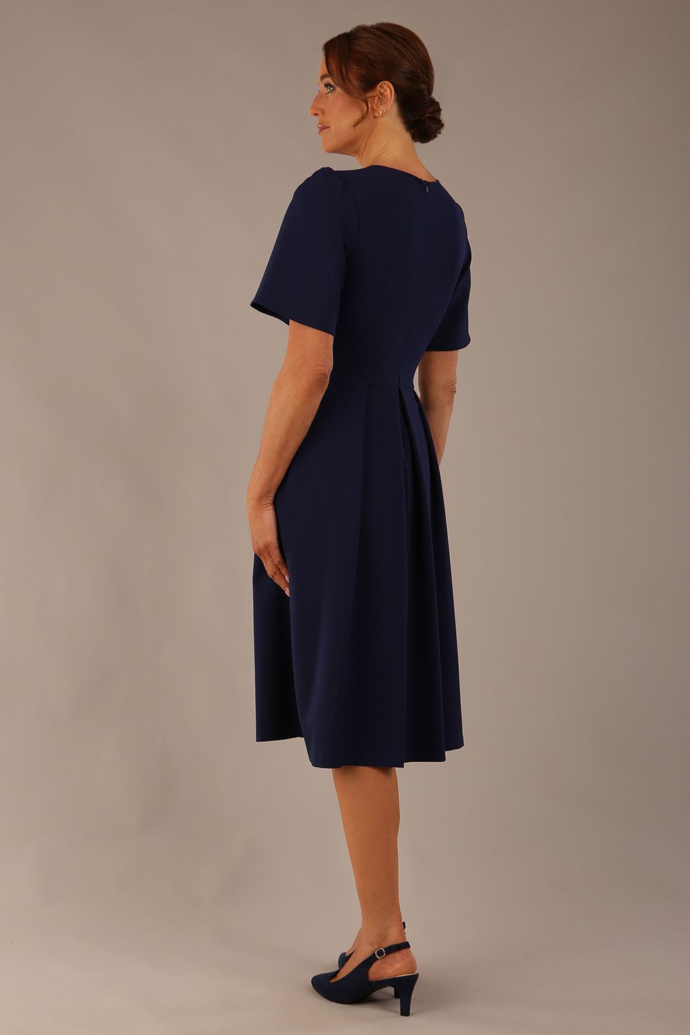 Model wearing the Dale pleated A-line dress against a plain background (Navy Blue)
