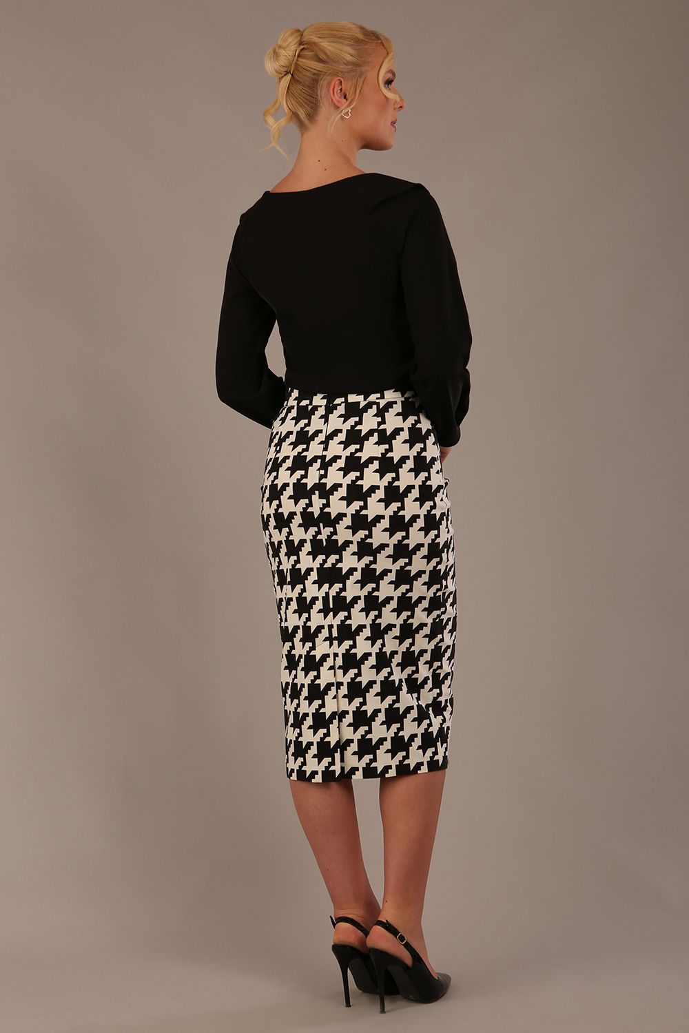 Woman wearing a diva catwalk cressida black top and houndstooth skirt against a neutral background (Black)
