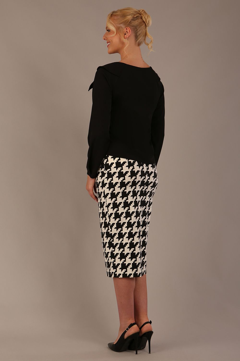 Woman sitting on a chair wearing a diva catwalk cressida black top and houndstooth-patterned skirt against a plain background (Houndstooth print)