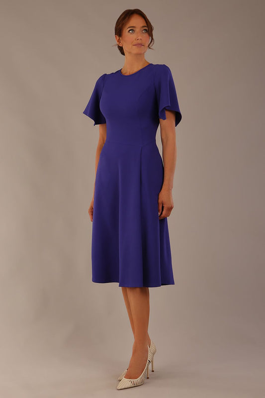 Model wearing a diva catwalk Anders petal sleeve A-line dress against a plain background (Spectrum Indigo)