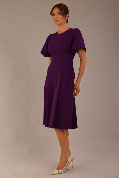 side view Model wearing a diva catwalk Anders petal sleeve A-line dress against a plain background (Purple)