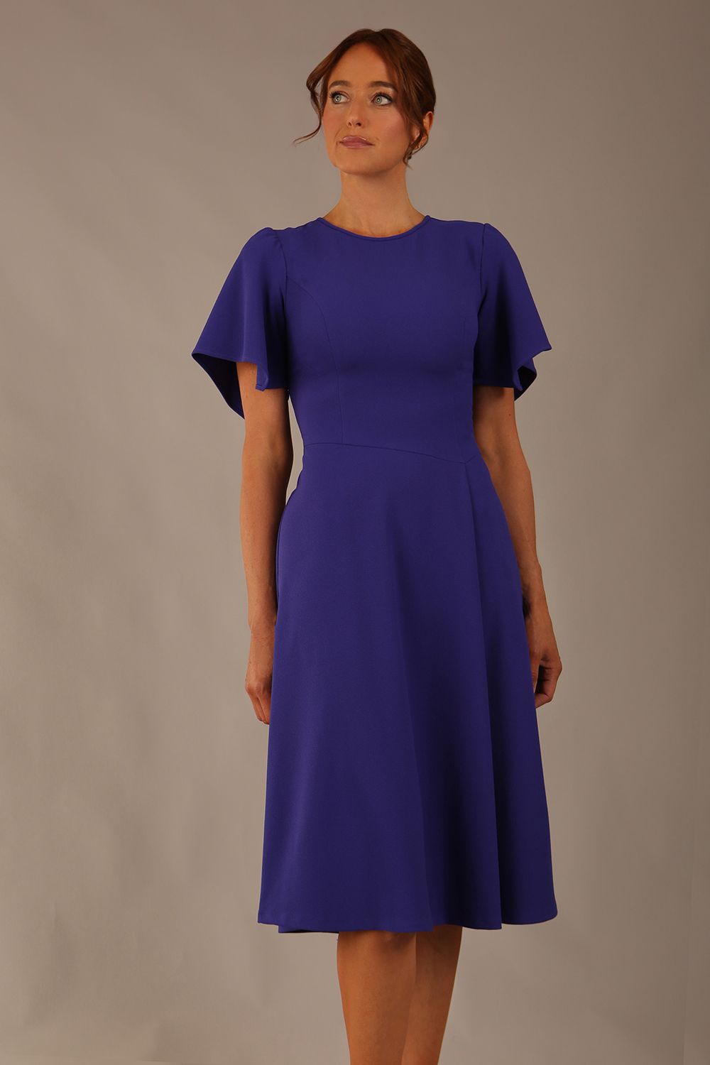 Model wearing a diva catwalk Anders petal sleeve A-line dress against a plain background (Spectrum Indigo)