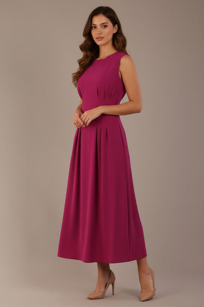 Model wearing the Cleo pleated midaxi dress in magenta with discreet side pockets (Magenta)