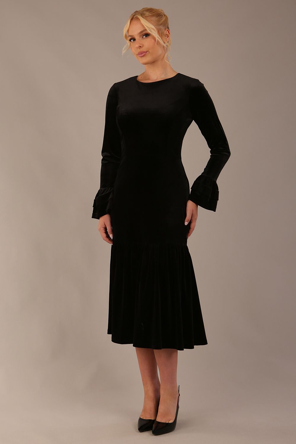 Model wearing the Sophisticat fluted sleeve velvet dress in black (Black Velvet)