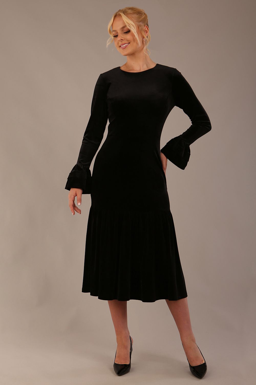 Model wearing the Sophisticat fluted sleeve velvet dress in black (Black Velvet)