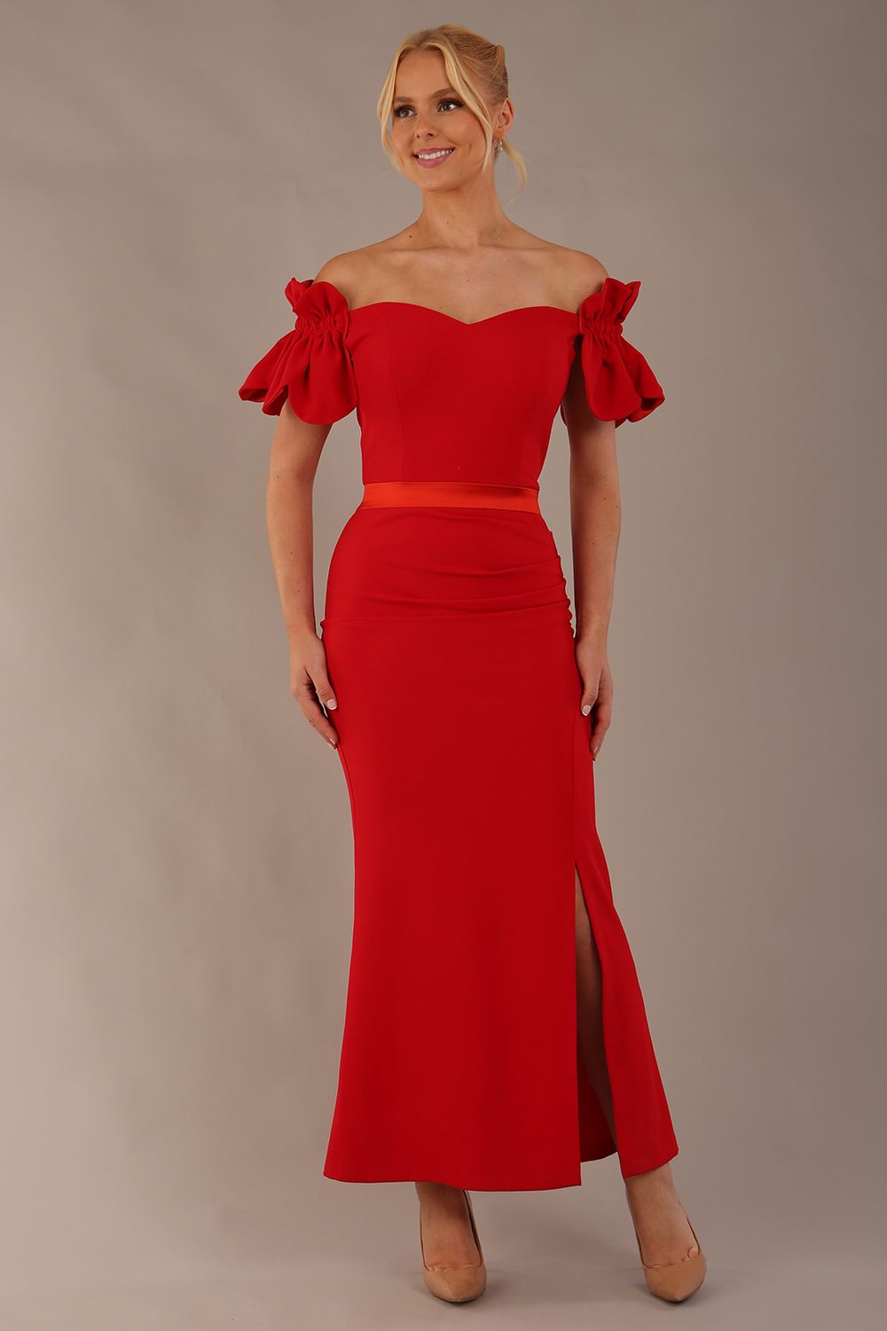 Woman wearing a red dress with ruffled sleeves in an elegant indoor setting. (Passion Red & Fire Orange Satin)