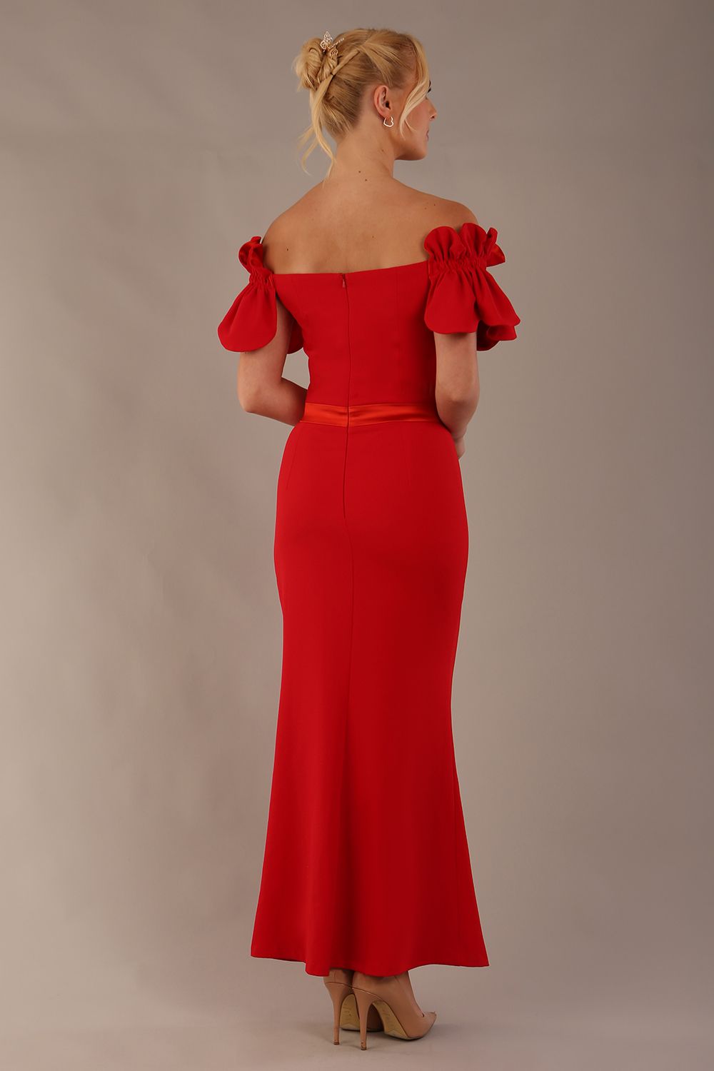 Woman wearing a red dress with ruffled sleeves in an elegant indoor setting. (Passion Red & Fire Orange Satin)