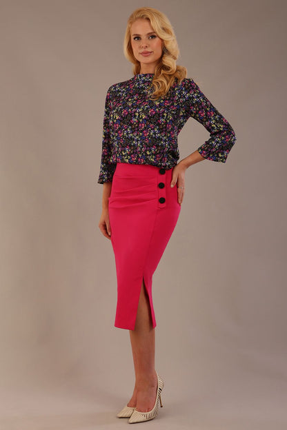 Blonde model wearing a fuchsia pink Claudette pencil skirt, showing the profile view with side buttons (Fuchsia Pink)