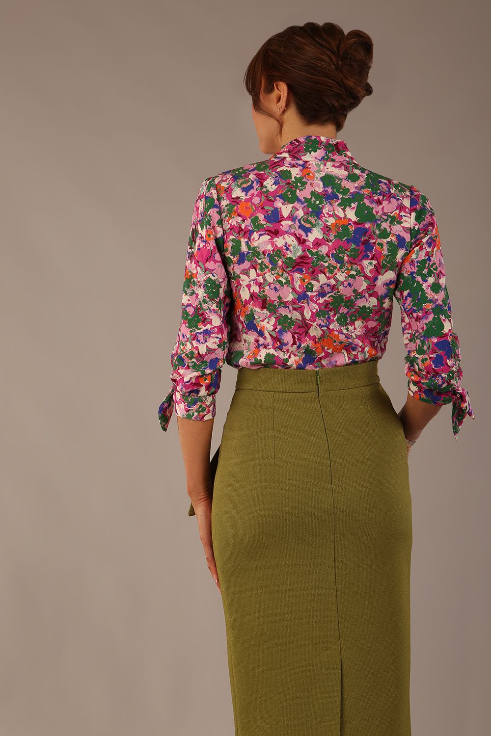 Model wearing a Radley Floral Tango print top with a central tie neckline and 3/4 sleeves, styled with an olive green skirt (Floral Tango)