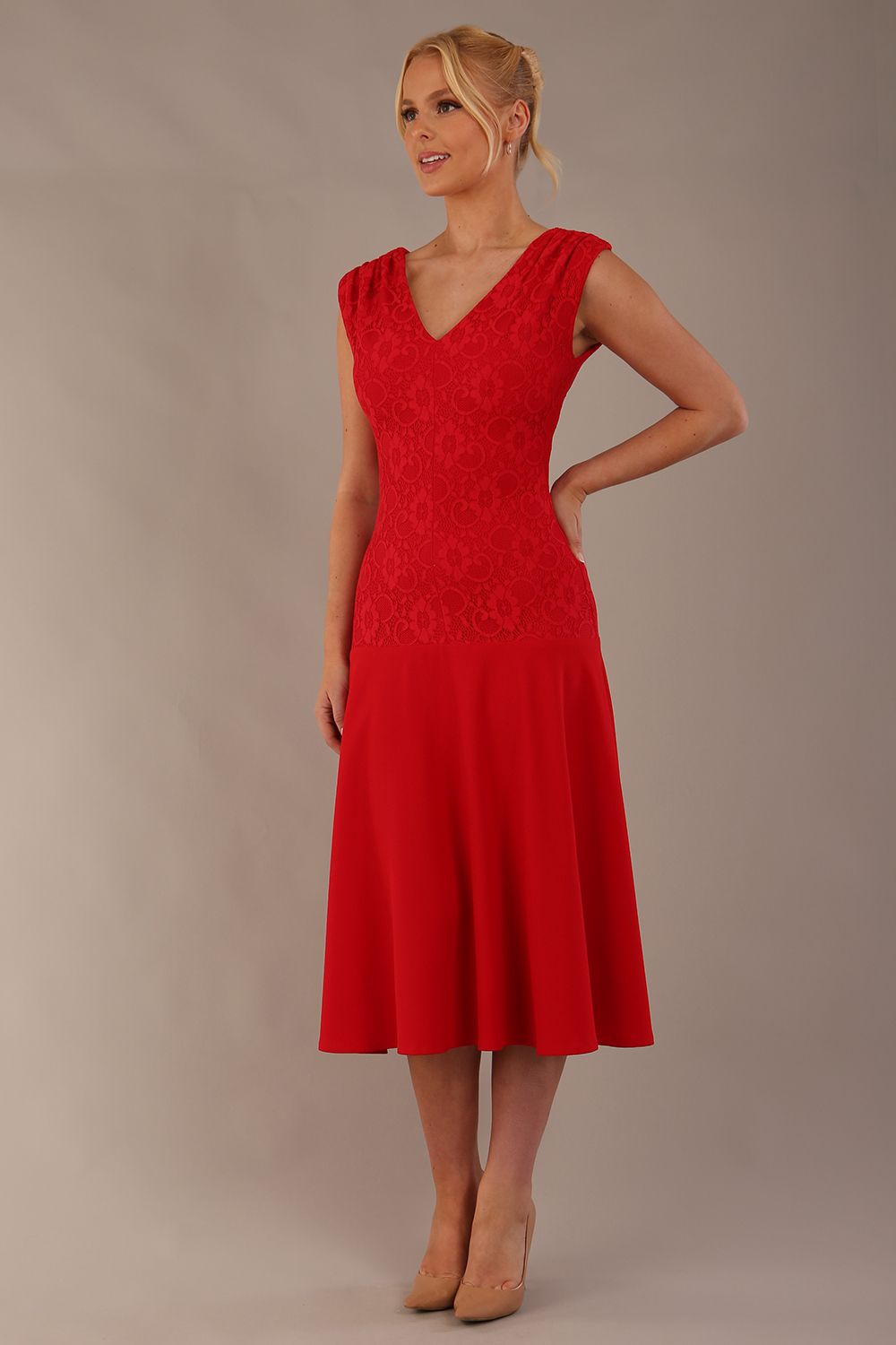 Woman wearing the Ayesha lace A-line midi dress in vibrant passion red against a neutral background (Passion Red)