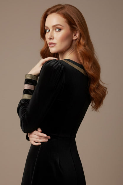 Woman wearing a black dress with gold accents sitting on a stool against a beige background (Black Velvet with Sherwood Glitter Contrast)