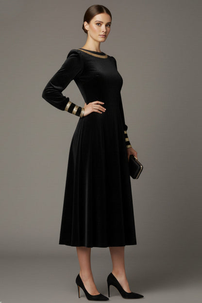 Woman wearing a black dress with gold accents sitting on a stool against a beige background (Black Velvet with Sherwood Glitter Contrast)