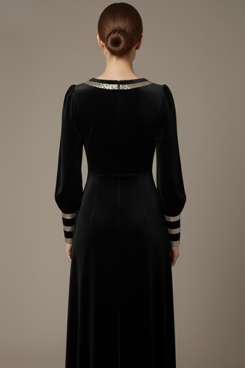 Woman wearing a black dress with gold accents sitting on a stool against a beige background (Black Velvet with Sherwood Glitter Contrast)