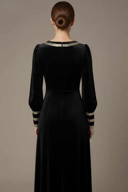 Woman wearing a black dress with gold accents sitting on a stool against a beige background (Black Velvet with Sherwood Glitter Contrast)