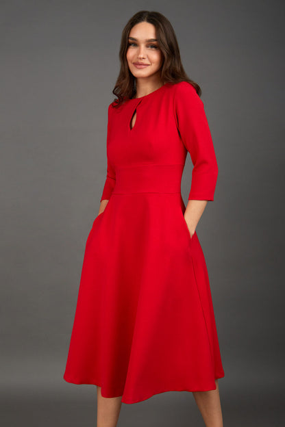 Brunette model is wearing diva catwalk casares swing dress with a keyhole neckline three quarter sleeve dress with pocket detail in red front (Scarlet Red)
