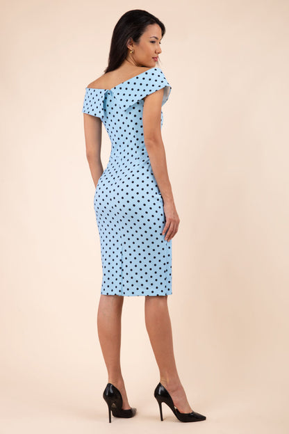 Brunette model wearing Diva Catwalk Fenella Polka Dot Pencil Sleeveless Dress off shoulder bardot neckline in blue front
