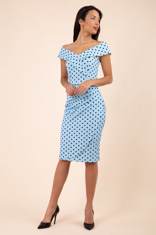 Brunette model wearing Diva Catwalk Fenella Polka Dot Pencil Sleeveless Dress off shoulder bardot neckline in blue front